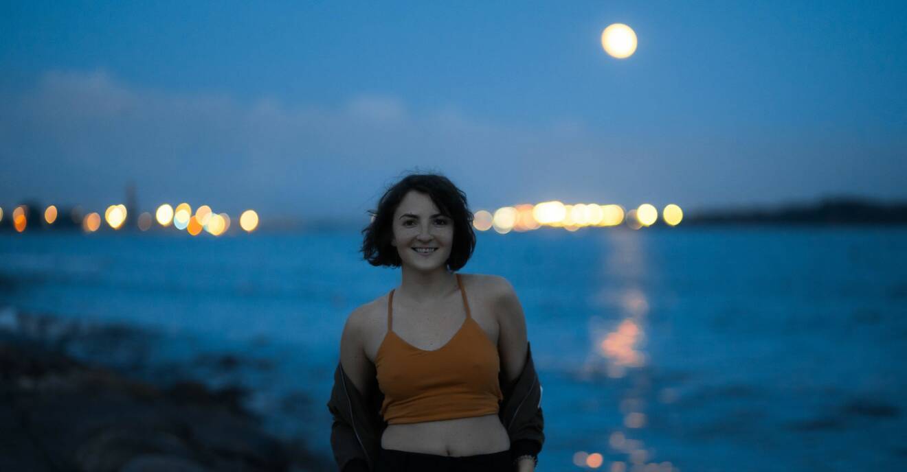Kvinna framför fullmåne.