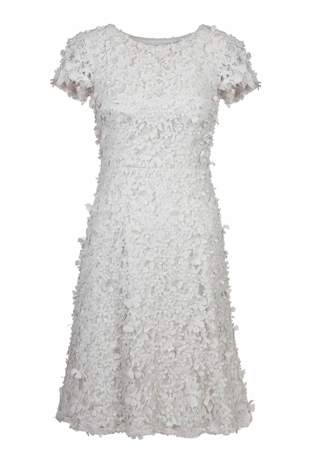 Vit kortärmad rundhalsad klänning i spets med 3D-blommor på. Vit klänning från Ida Sjöstedt.