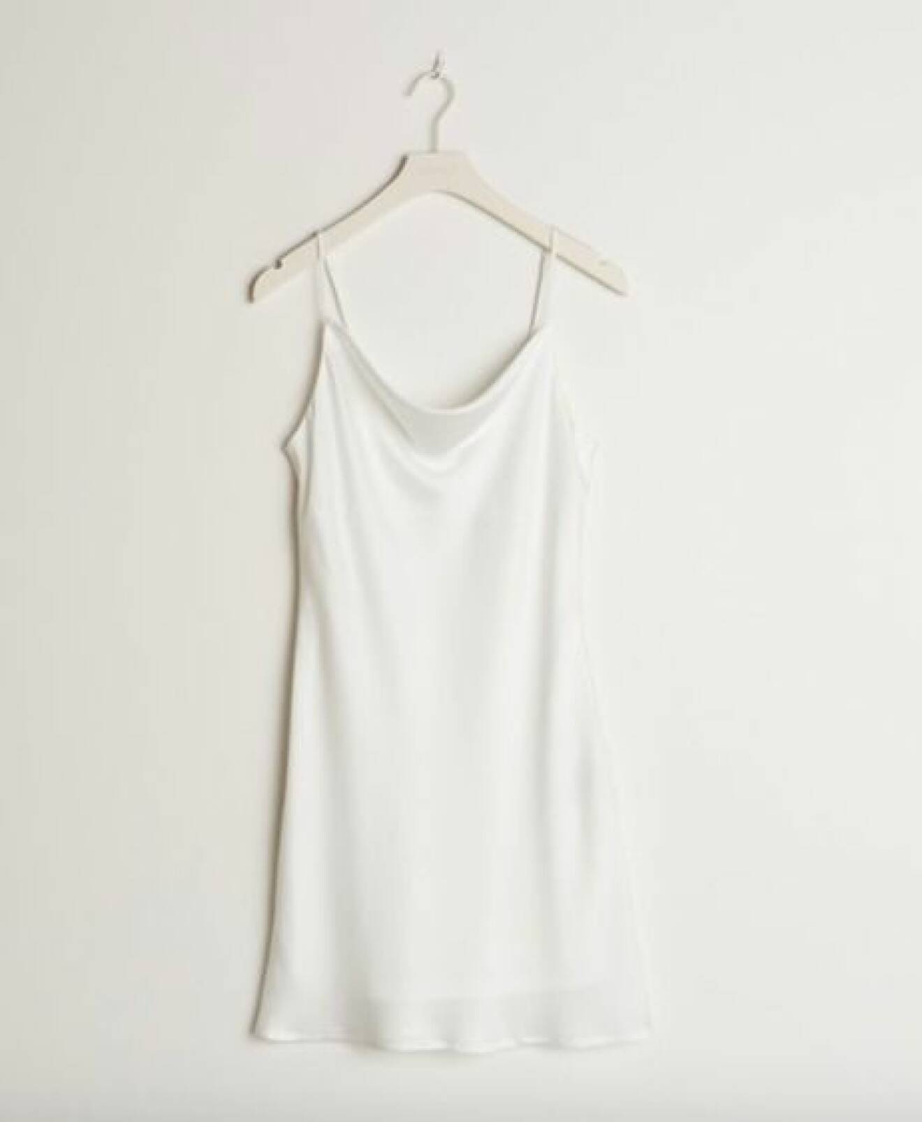 Minimalistisk kort vit klänning i silkigt material. Tunna axelband och drapering framtill. 90-tals inspirerad klänning från Gina tricot.