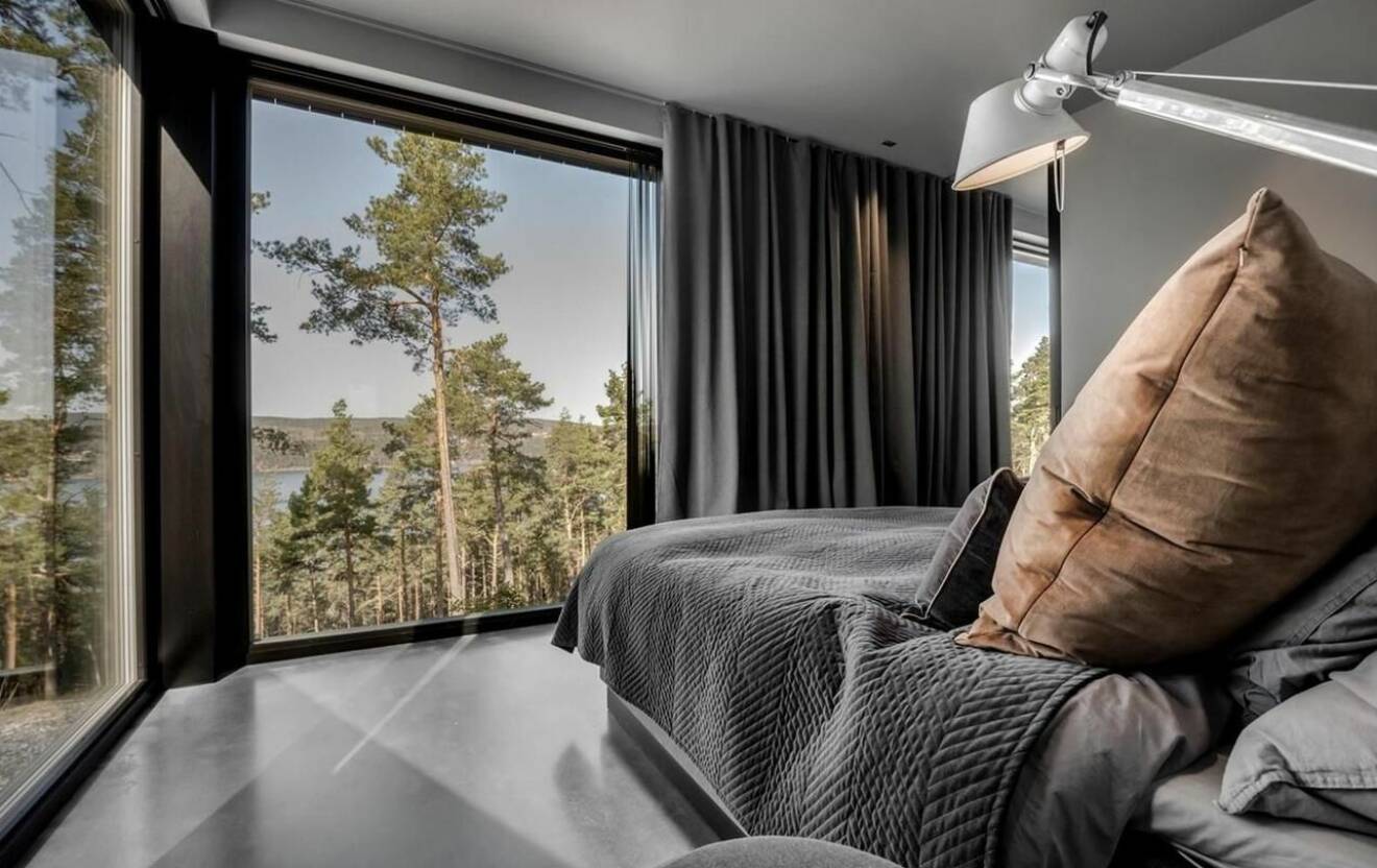 ett sovrum med utsikt över skog