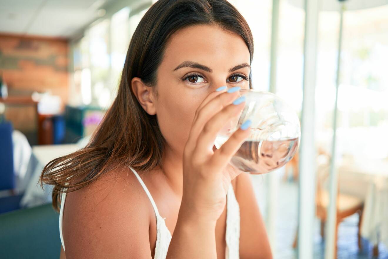 Kvinna dricker vatten.