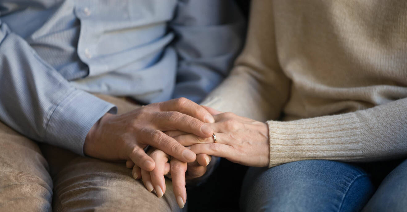 Ett äldre par håller handen.