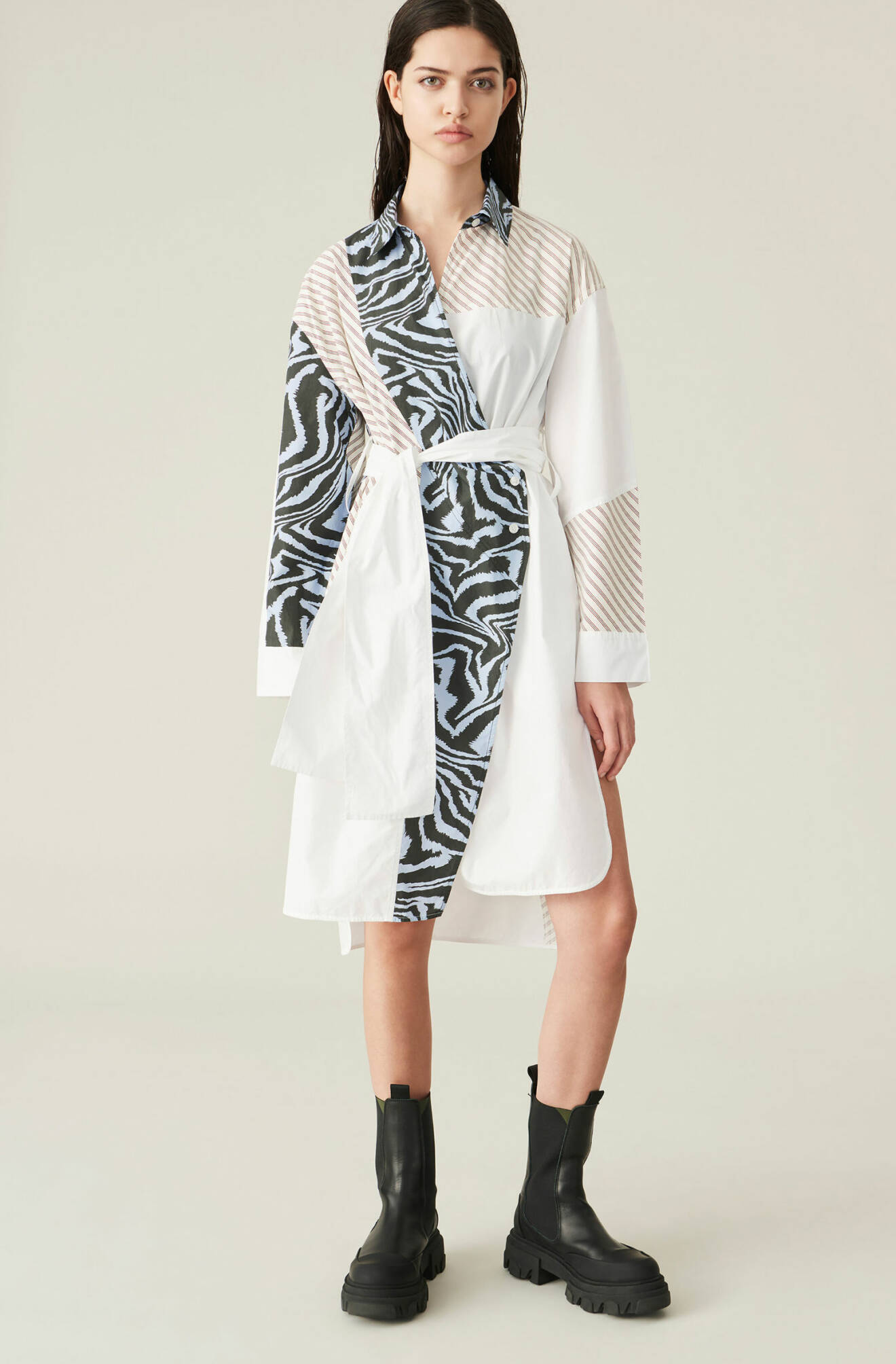 Modell i skjortklänning som är blockmönstrad i vitt, randigt och zebramönstrat. Skjortklänning från Ganni.
