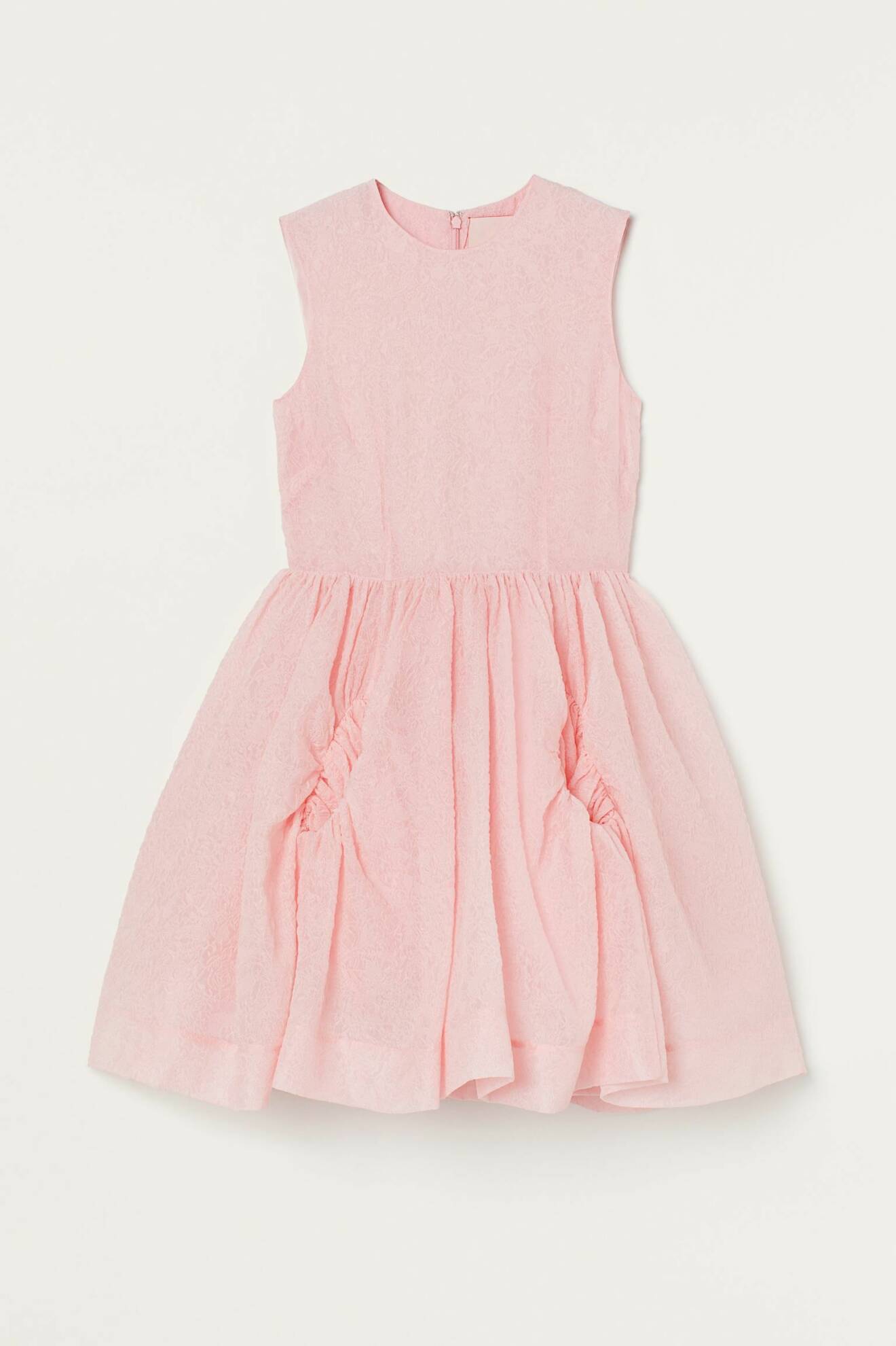 Ljusrosa klänning utan ärmar och vid kjol med fickor framtill. Klänning, H&amp;M.