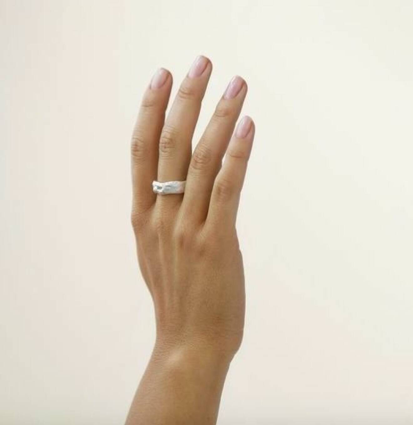 En hand med en bred, silverring med struktur på långfingret. Ring från Nootka jewlery.