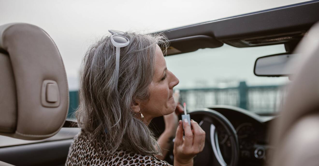 kvinna som målar läpparna i bilen
