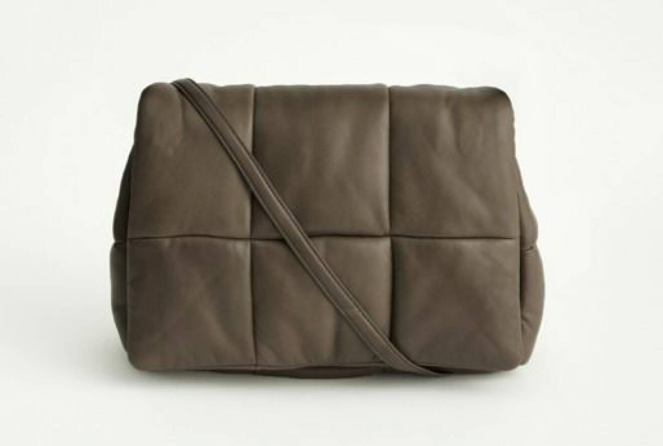 Mörkbrun skinnväska med smal axelrem. Kan användas som kuvertväska. Väskan är mjuk och ser ut som den är "uppstoppad". Väska från Stand studio.