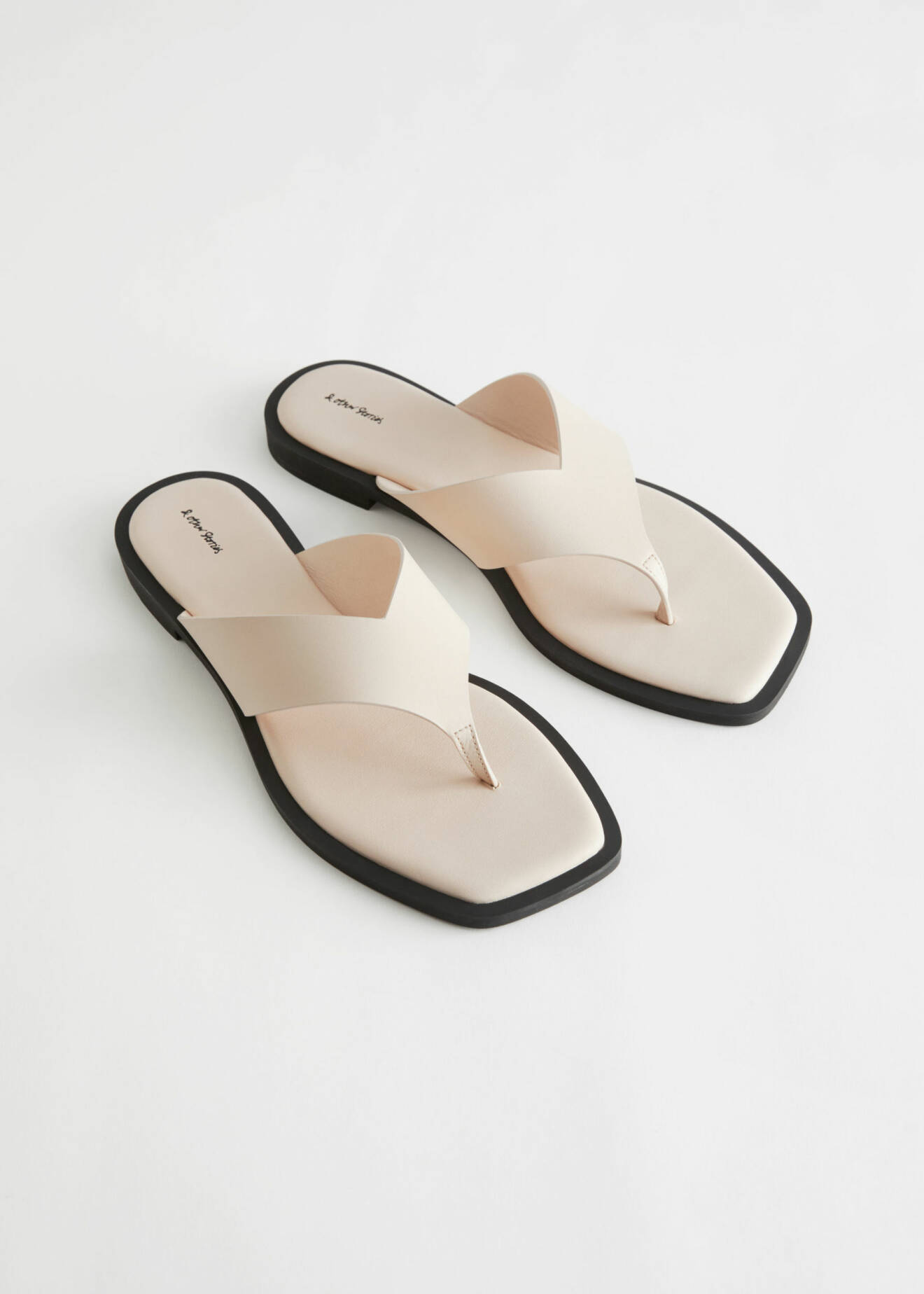 Platta sandaler i beige skinn. Flip-flop-modell. Sandaler från And other stories.