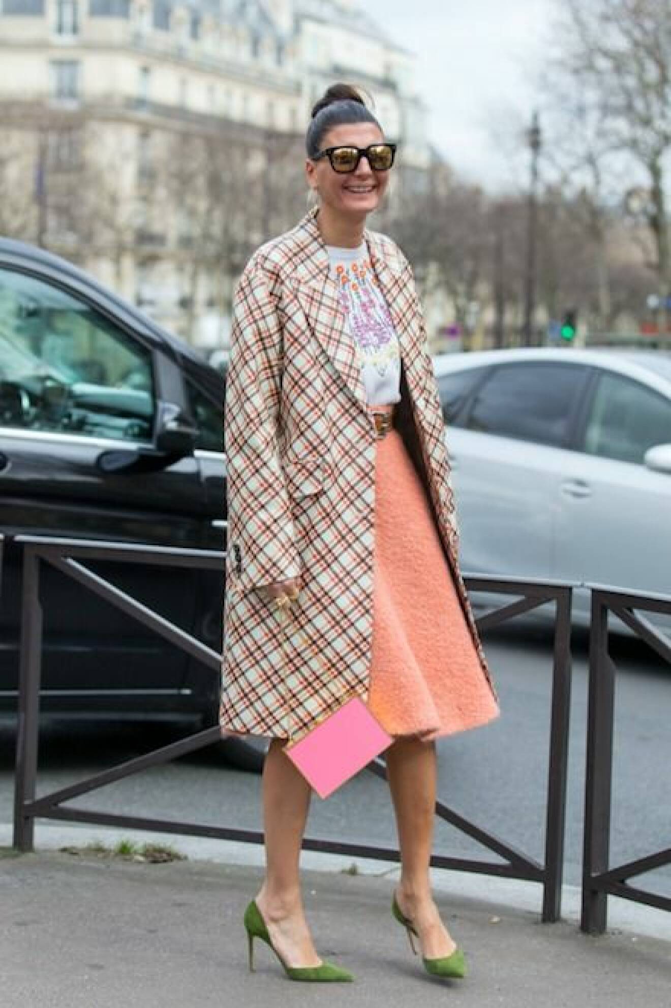 Giovanna Engelbert i färgglad och mönstrad outfit. Hon matchar en rosa kuvertväska med gröna pumps.