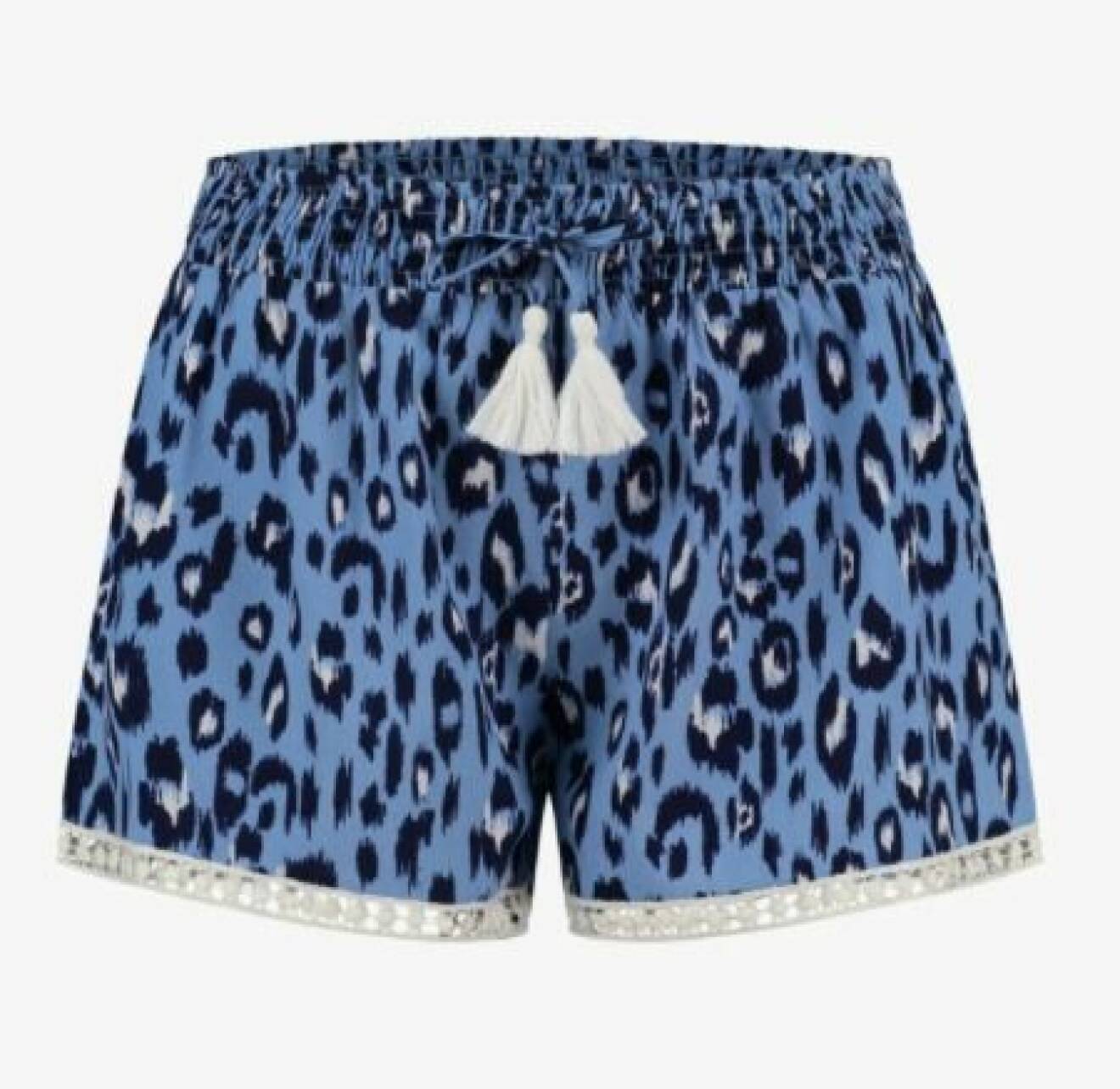 Korta shorts med resår i midjan och knytdetalj med vita toffsar. Blå leopardprint och en spetskant vid bensluten. Shorts från Shiwi.
