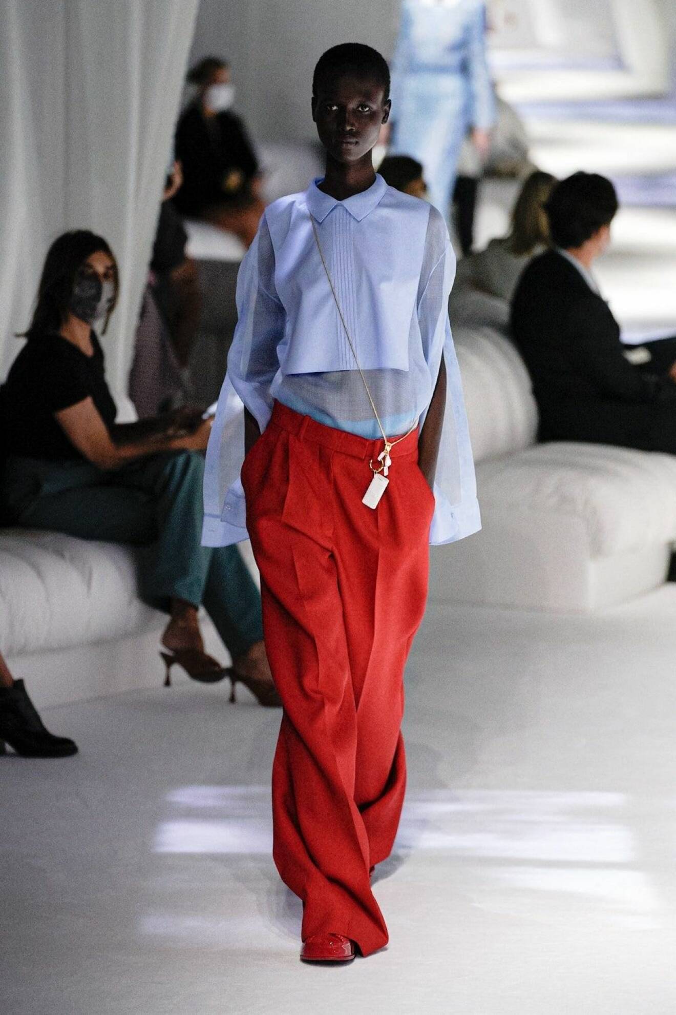 Modell med oversizad ljusblå skjorta och långa, röda byxor. Look från Fendi ss21.