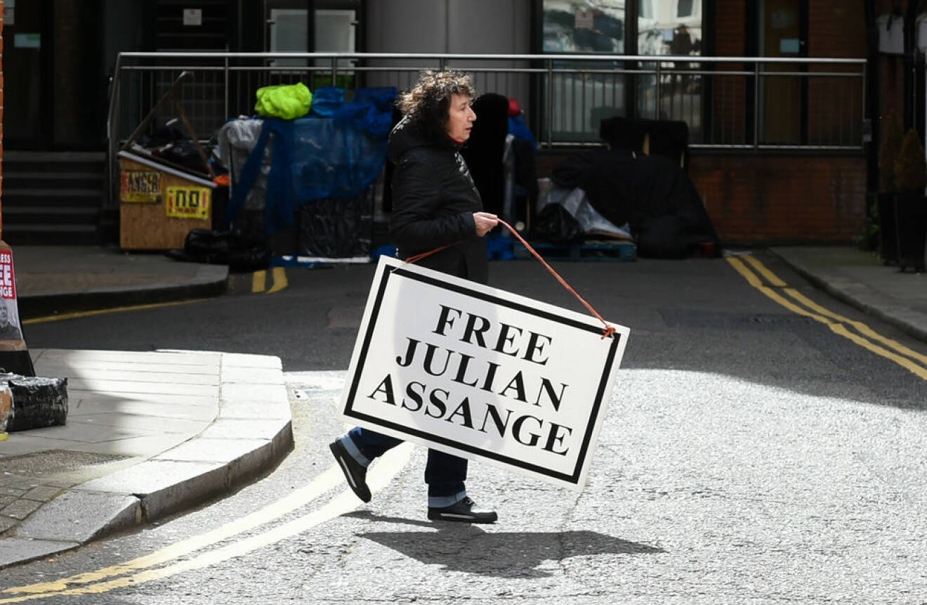 Kvinna som håller i en skylt om att frige Julian Assange.