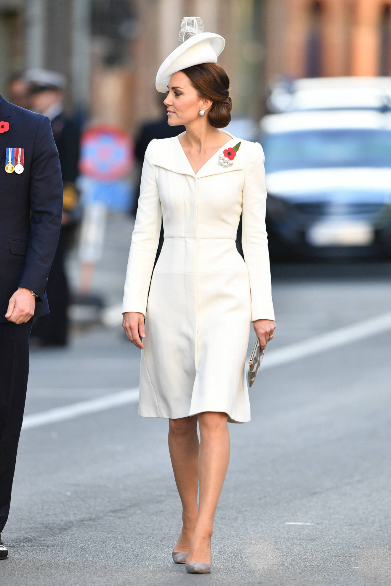 Kate Middleton i cremefärgad klänning med hatt och håret har hon i en prydlig knut i nacken.