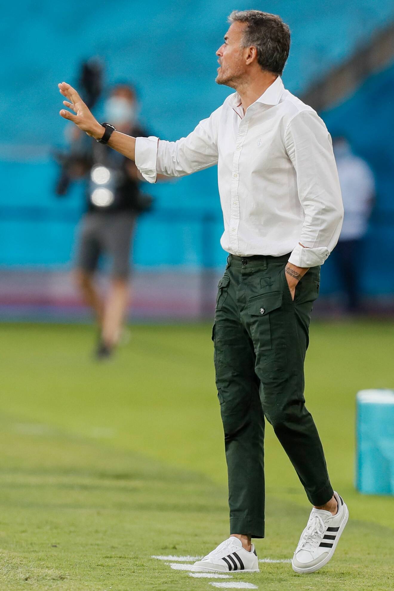 Luis Enrique under matchen Spanien-Sverige i gröna byxor, skjorta och adidas-sneakers