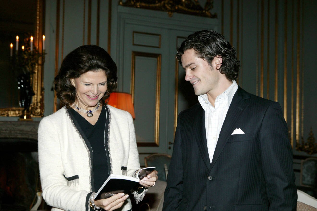 Drottning Silvia i vit dräktjacka från Chanel. Här tillsammans med Carl Philip på Stockholms slott år 2004.