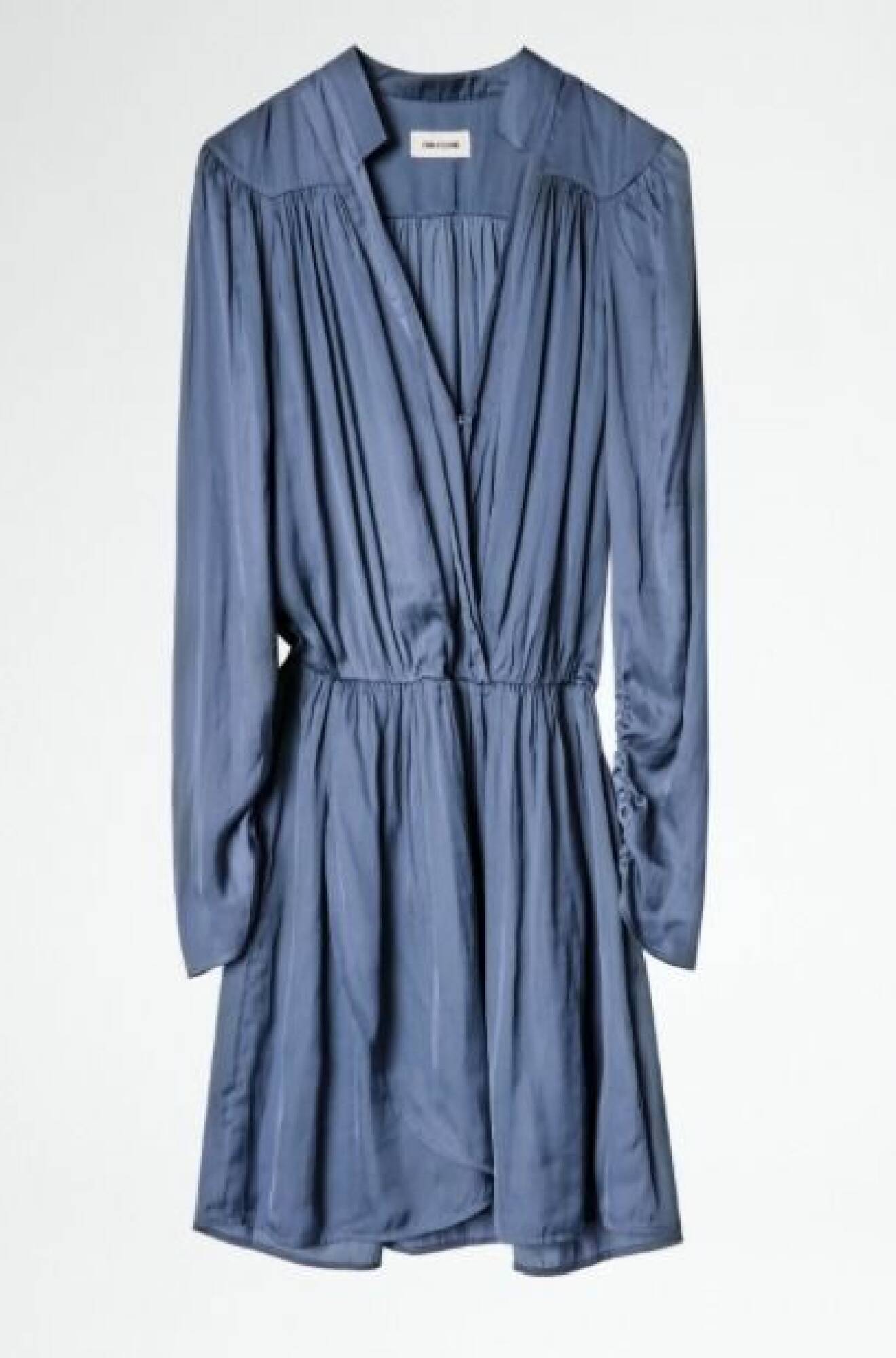 Duvblå klänning i silkigt material i skjortmodell. Klänningen har långa ärmar och markerad midja. V-ringad med wrapkänsla. Klänning från Zadig &amp; Voltaire.