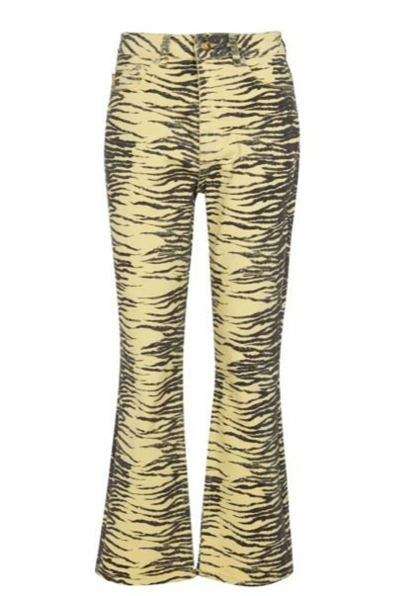 Tigermönstrade jeans i pastellgult och svart. Jeansen är croppade med utställda ben nertill. Jeans från Ganni.