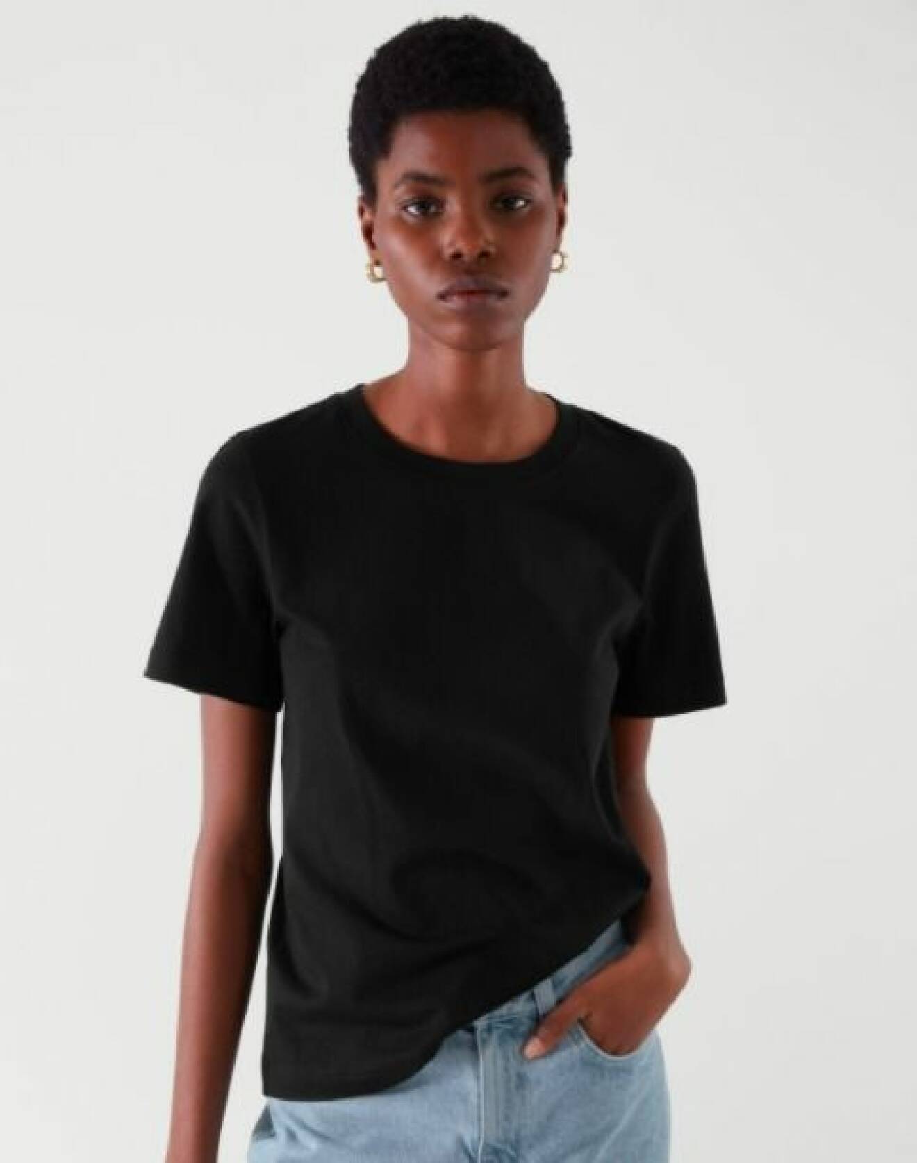 Modell med svart, klassisk t-shirt i rak modell. T-shirt från Cos.