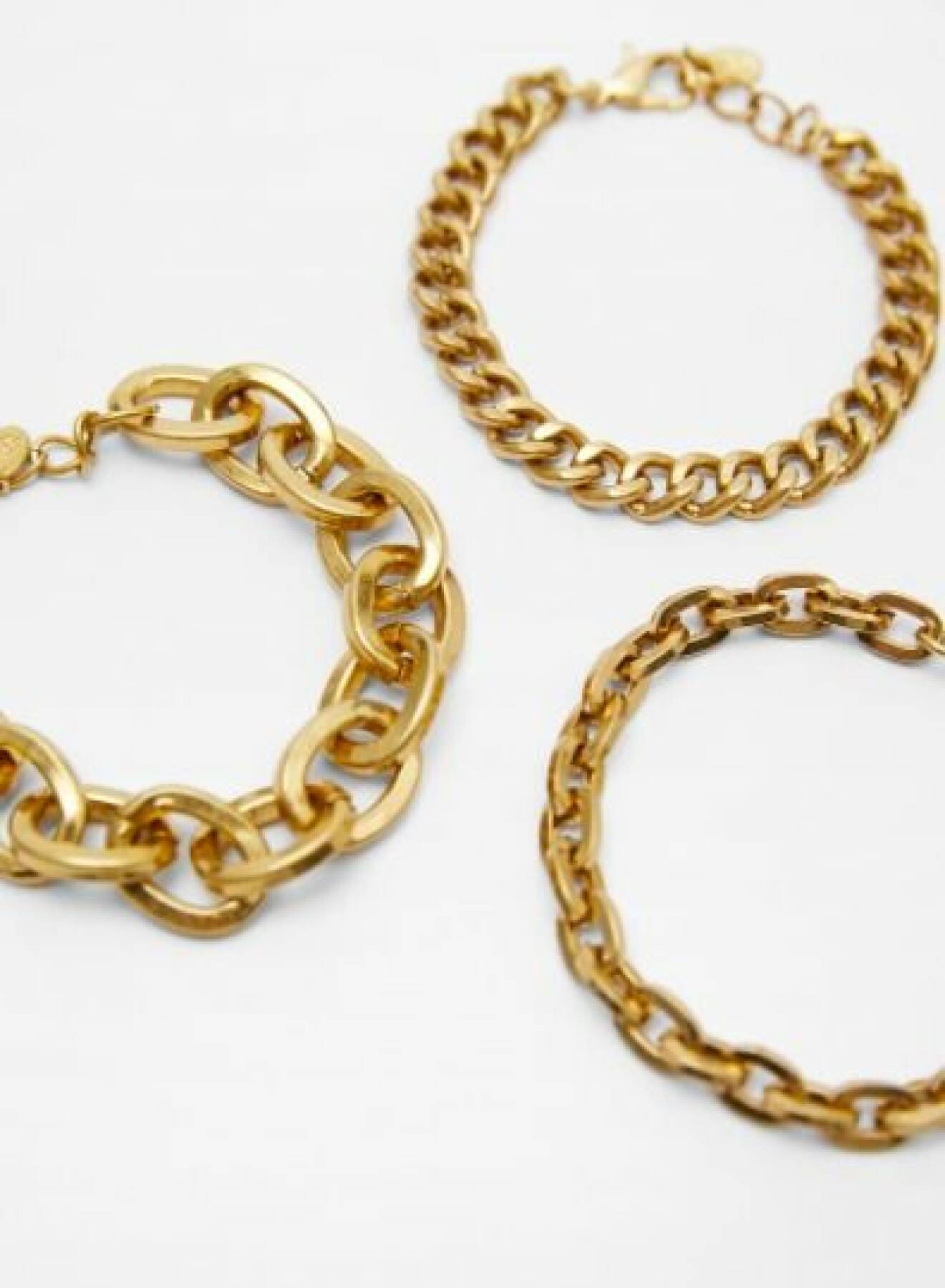 Tre armband i form av guldfärgade kedjor i olika storlekar. Armband i 3-pack från Zara.