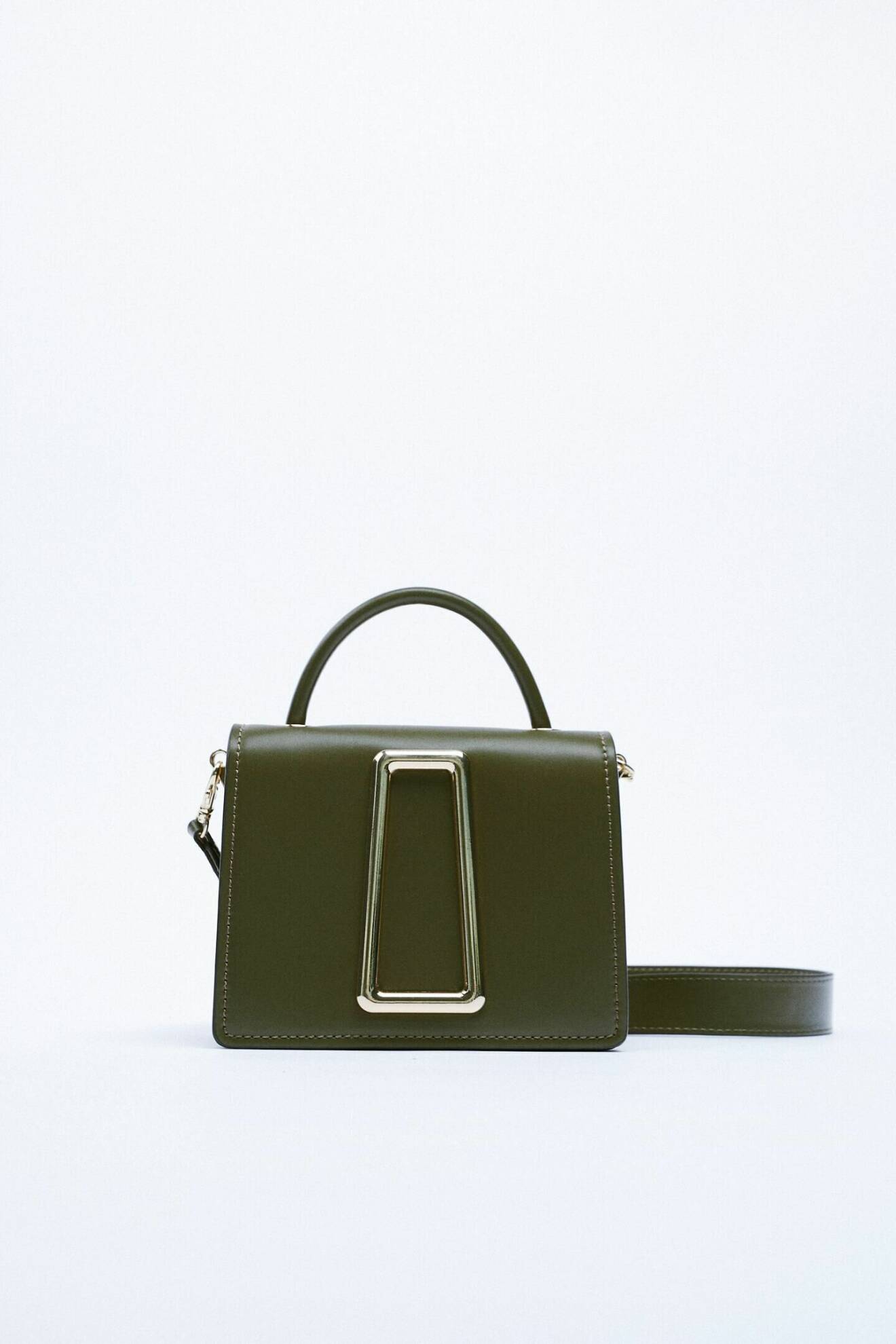 Skogsgrön väska i mindre modell med guldfärgat spänne på. Både litet handtag och lång axelrem. Väska från Zara.