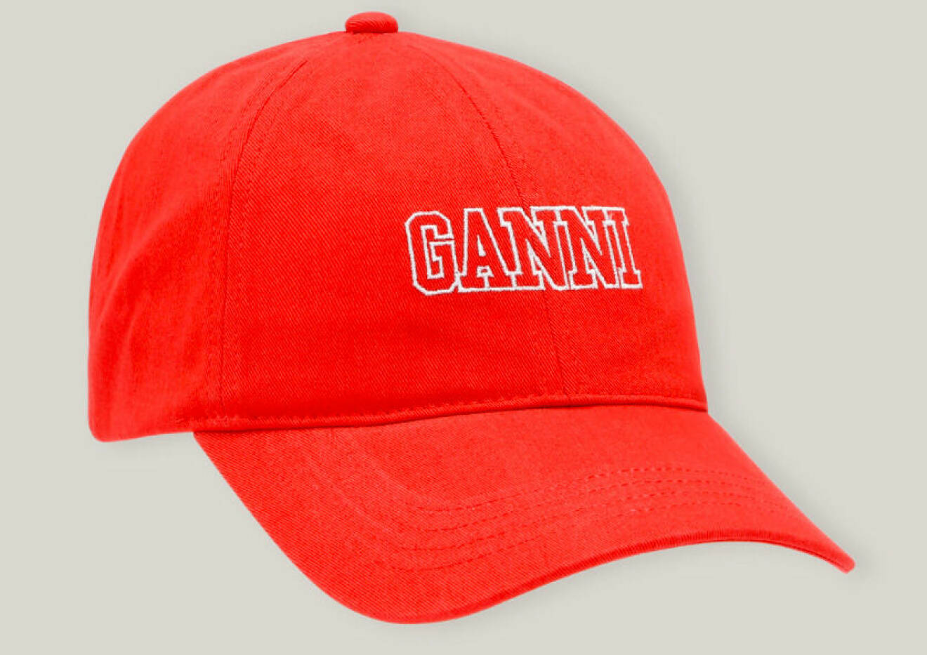 Röd keps med broderas vit logga med texten "Ganni". Keps från Ganni.