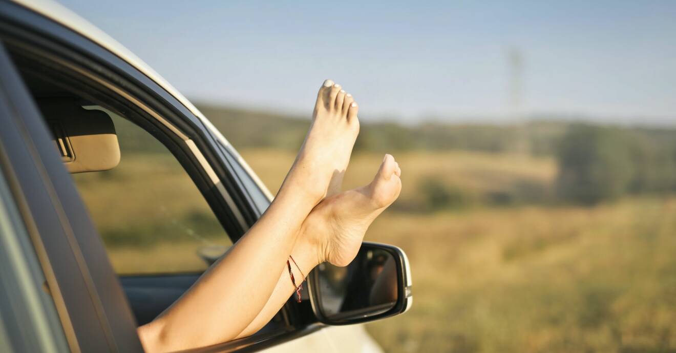 fötter med målade tånaglar som sticker ut genom bilfönstret