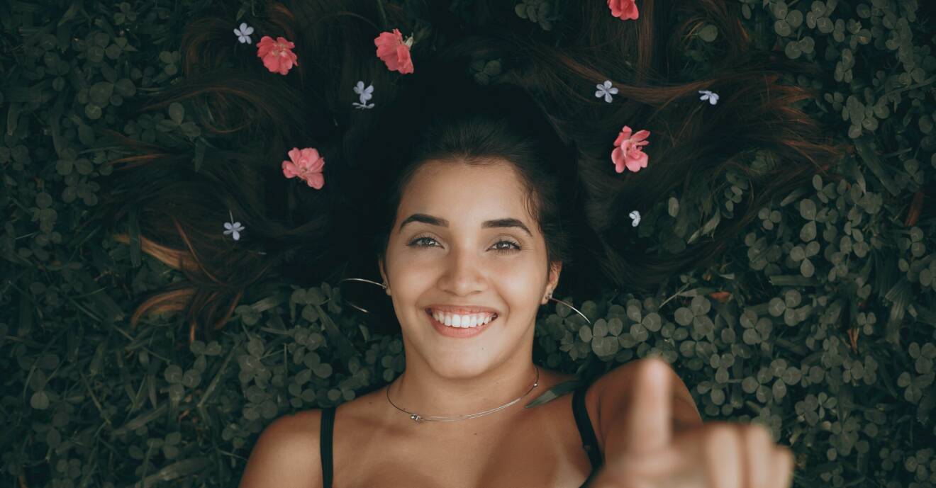 kvinna med blommor i håret som skrattar