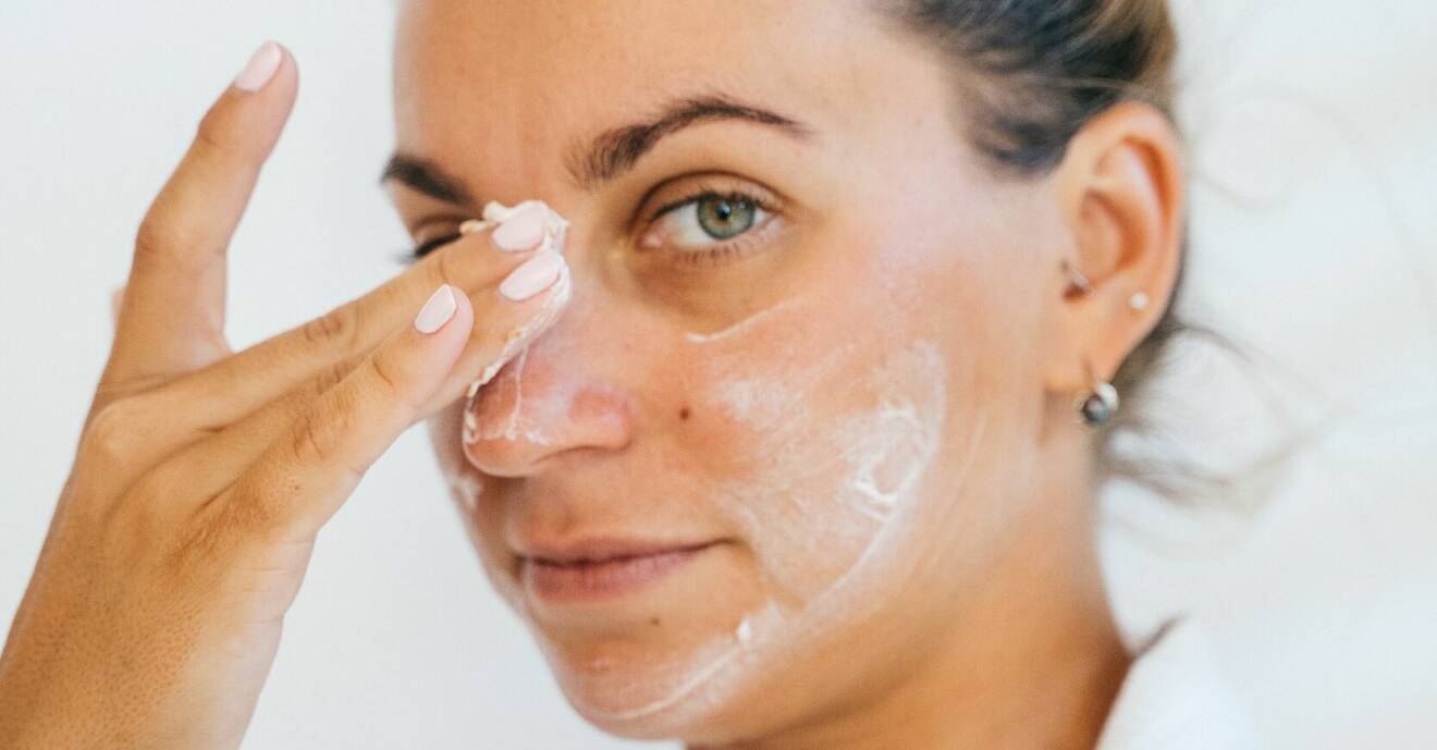 kvinna smörjer in ansiktet med hudkräm