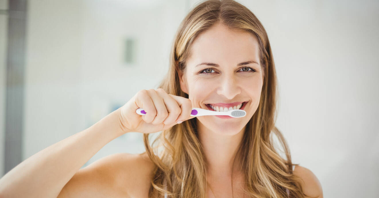 Kvinna borstar tänderna.