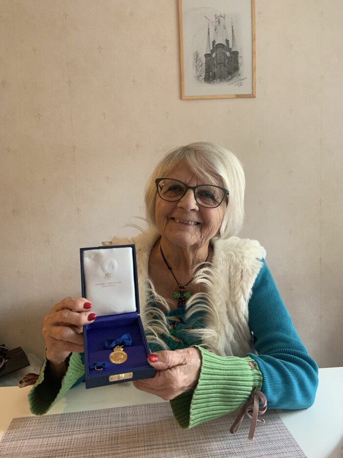 Elise Lindqvist trodde att hovet hade skrivit fel när inbjudan till medaljceremonin kom. Elise Lindqvist håller stolt upp hedersmedaljen från kungen.