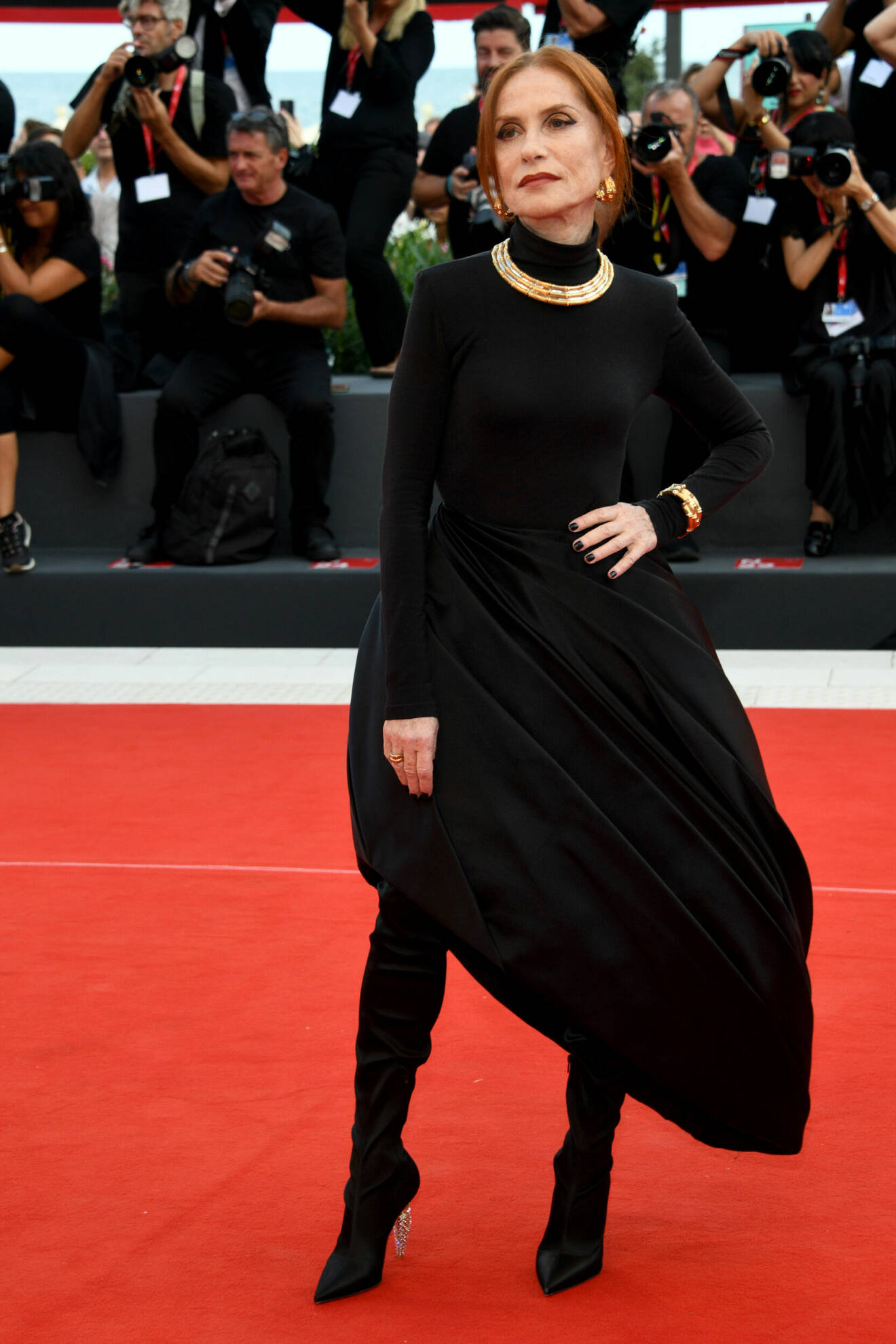 Isabelle Huppert i svart galaklänning med guldsmycken.