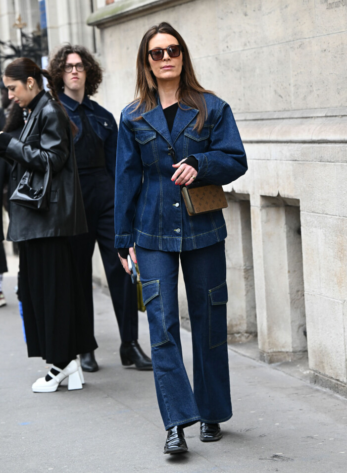 Stilsäker gäst iklädd dubbel dos av denim under modeveckan i Paris. Gäst vid modeveckan i Paris iklädd blå cargojeans och matchande jeansjacka.