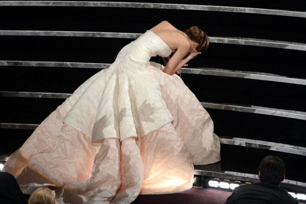 Här faller Jennifer Lawrence i trappen när hon är på väg upp för att ta emot sitt pris. Jennifer Lawrence ligger i en trapp med en stor vit klänning