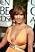 Jennifer Lopez i en knallorange empirskuren klänning med guldfärgade detaljer som ett virat skärp runt överkroppen och på axlarna. Stora droppformade örhängen med strass på.