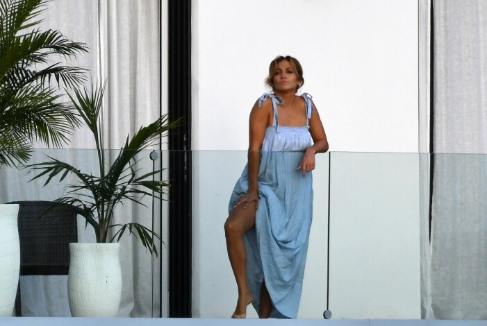 Jennifer Lopez svalkar sig på balkongen. jennifer lopez i blå klänning på balkong