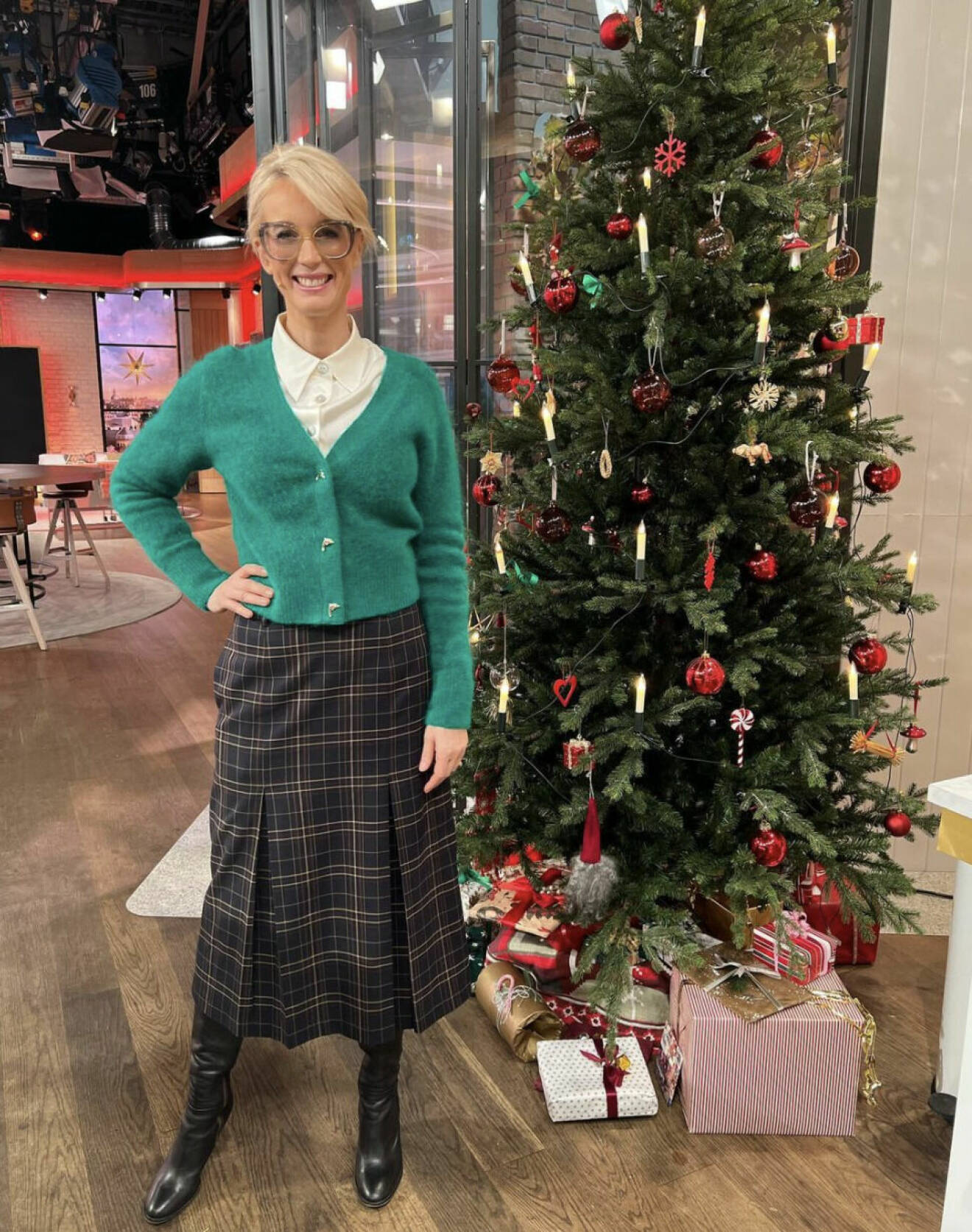 Jenny Strömstedt i TV4 Nyhetsmorgon i en grön kofta med guldknappar och rutig lång kjol