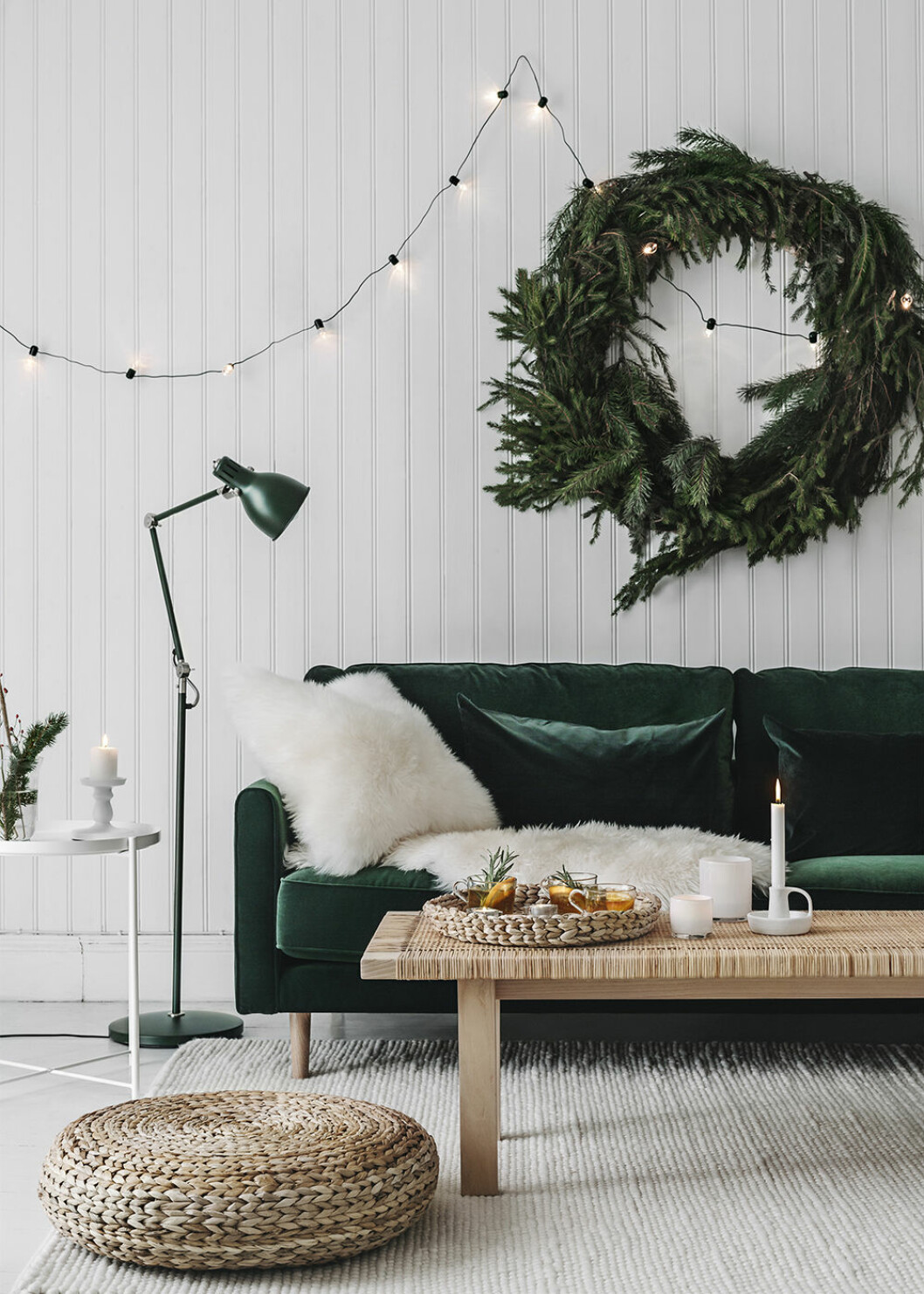 Kransen är lika snygg inne som ute. Foto: Ikea Stor julkrans och mörkgrön sammetssoffa hos Ikea