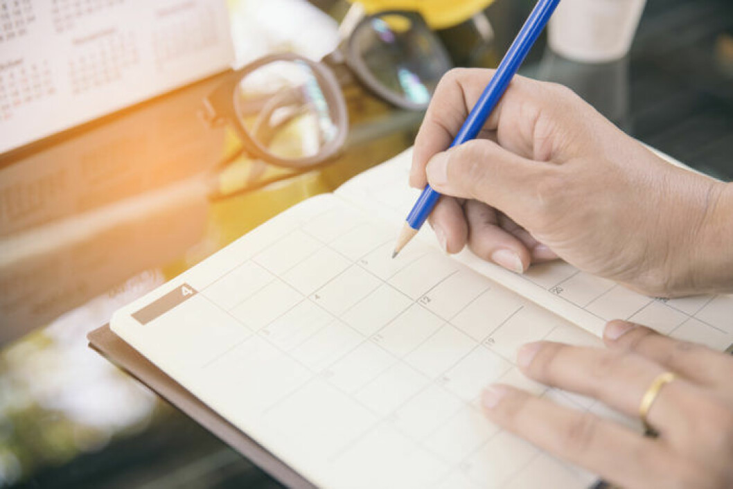 Bild: Shutterstock/IBL Kvinna skriver i en kalender.