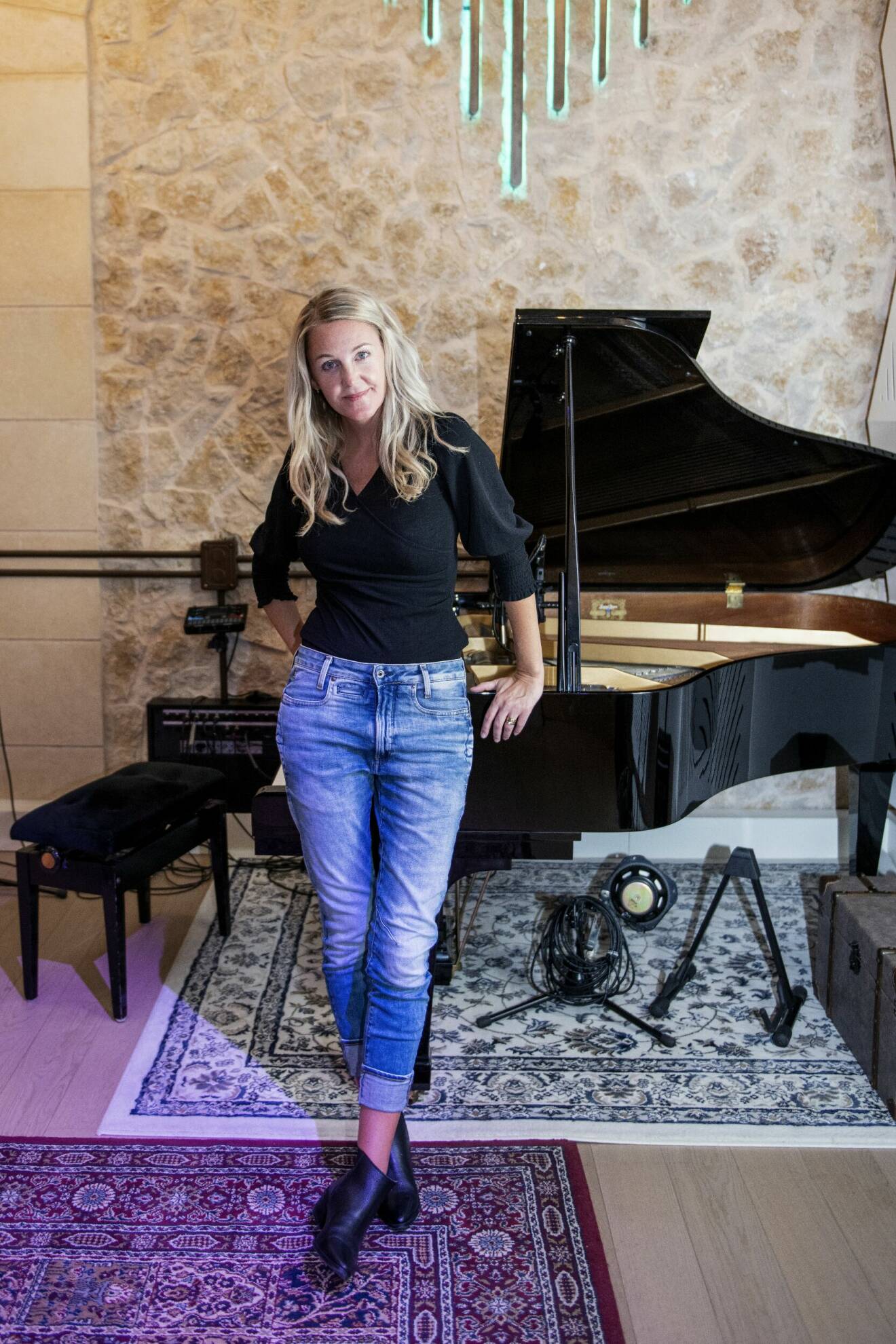 Karolina Hellman står framför ett piano.