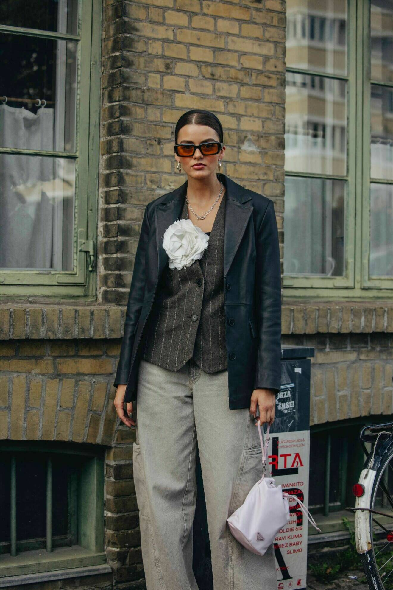 Kritstrecksrandig kostymväst med skinnkavaj och vida jeans på Köpenhamns modevecka