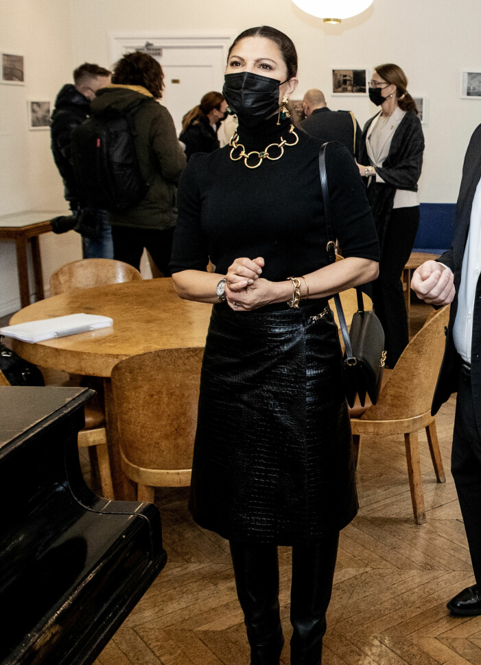 Kronprinsessan bär en helsvart look där det återigen är detaljerna som lyfter helheten. Kronprinsessan matchar polotröjan med ett stort halsband.