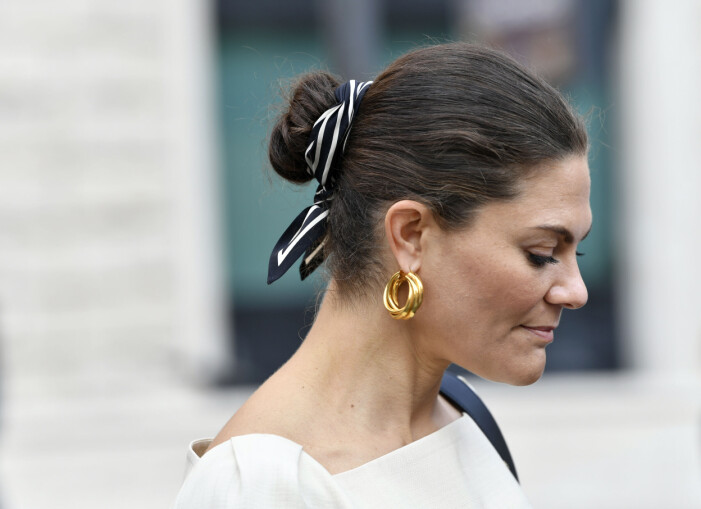 Kronprinsessan bär scarf i håret som en dekorativ detalj. Victoria knyter en sjal som en dekorativ detalj i håret.