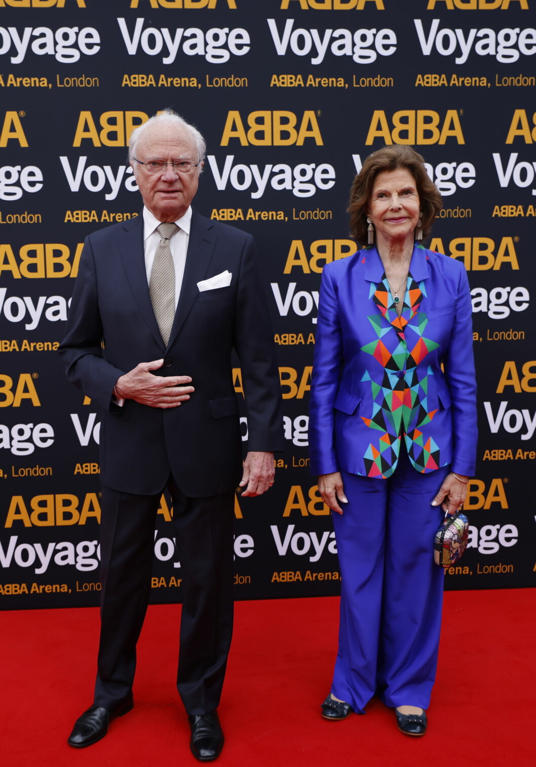 Sveriges kungapar på plats under ABBA Voyage. Enligt sajten UFO No More bar drottningen kostym från Thalia, och en clutch från Romero Britto.