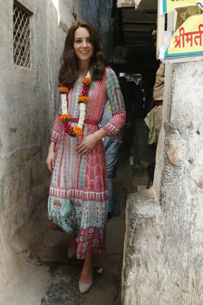 Kate Middleton i Mumbai, klädd i indisk design. Foto: TT Kate Middleton i kläder av en Indisk designer under sitt besök i Mumbai. Kate bär mönstrad klänning i rött och turkost samt ett långt blomhalsband runt halsen.