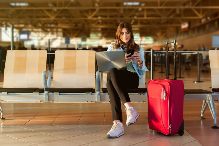 De som är ute i god tid tycker inte om de sena passagerarna. kvinna flygplats väska telefon laptop vänthall
