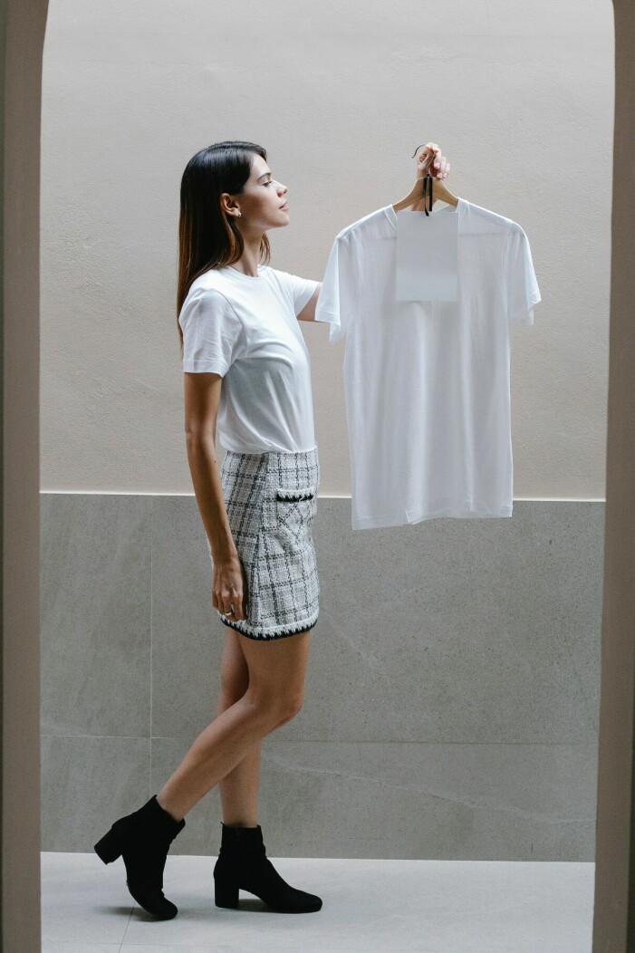 En kvinna håller en vit t-shirt.