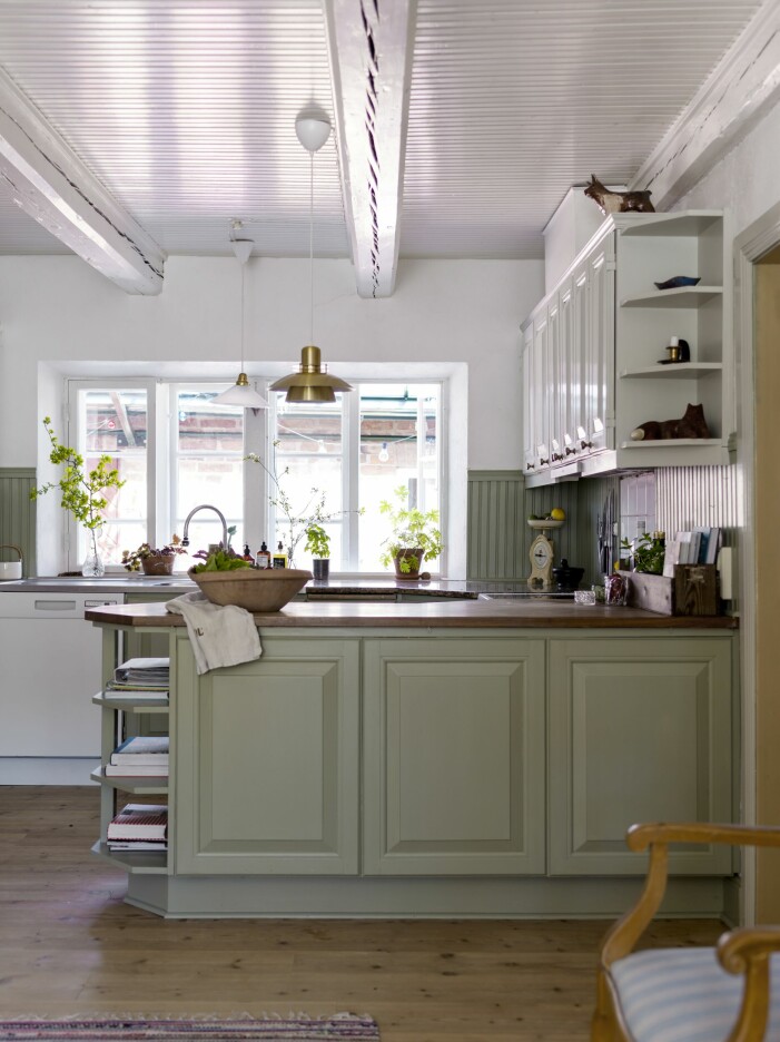 Det platsbyggda köket fanns i huset vid köpet och har sedan dess målats om i pärlgrå och antikgrön linoljefärg från Ottosson Färgmakeri. Platsbyggt kök i ljus grön färg.