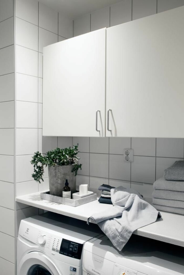 Ett rymligt badrum med både tvättmaskin och torktumlare.