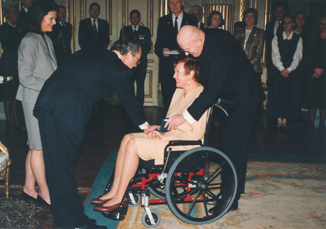 Maj Fant får medalj av kung Carl XVI Gustaf och drottning Silvia. Maken Ove Edmark är med. Året är 1995. maj fant får medalj av kungen