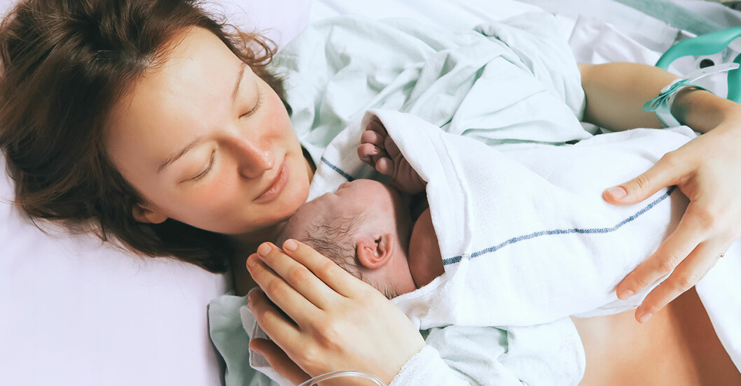 Kvinna med sitt nyfödda barn i famnen